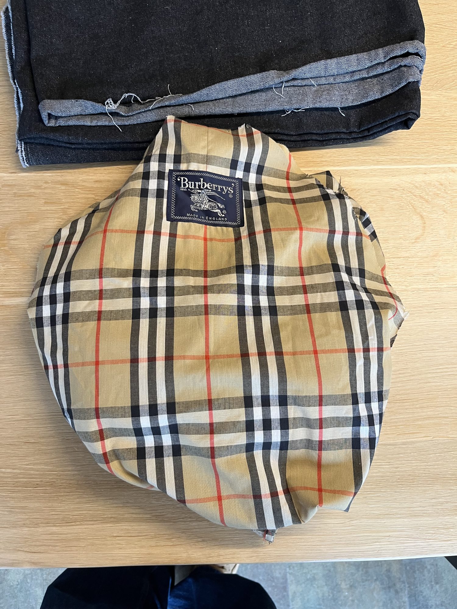 Zusammengelegte Jeans mit dem gewählten Karo-Stoffdetail obenauf