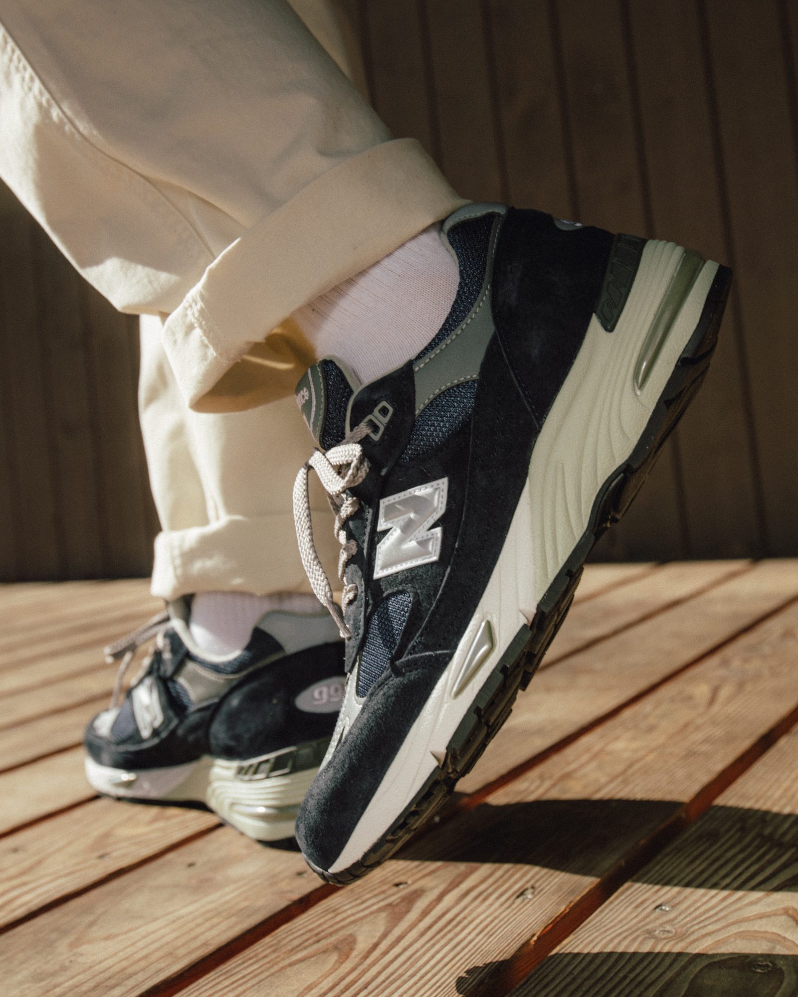 Fuss mit Sneaker auf einer Holzterrasse